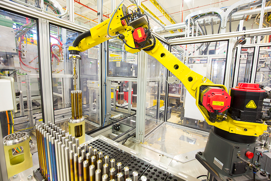 A robot precisely inserts fuel rods into a nuclear fuel assembly. 