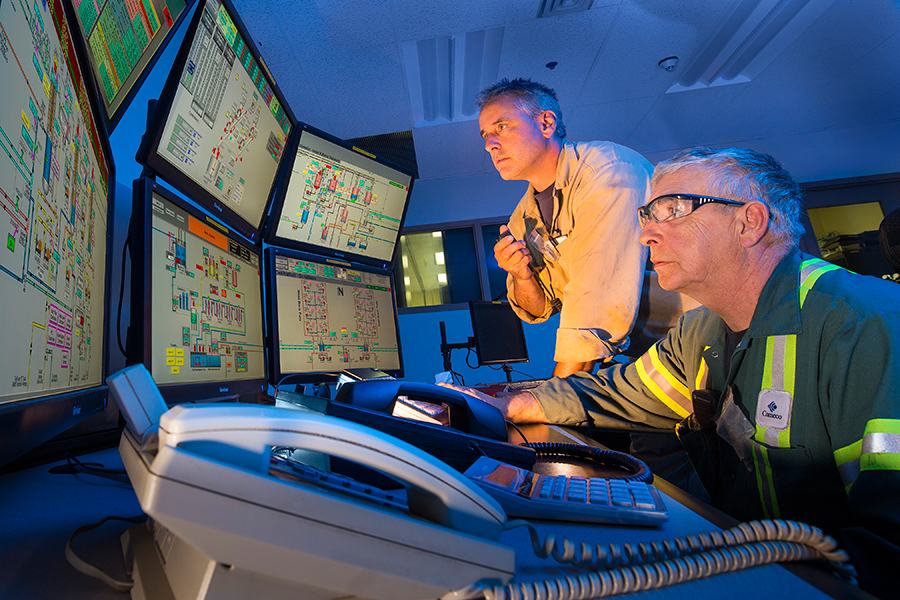 Workers monitor uranium refinement processes. 